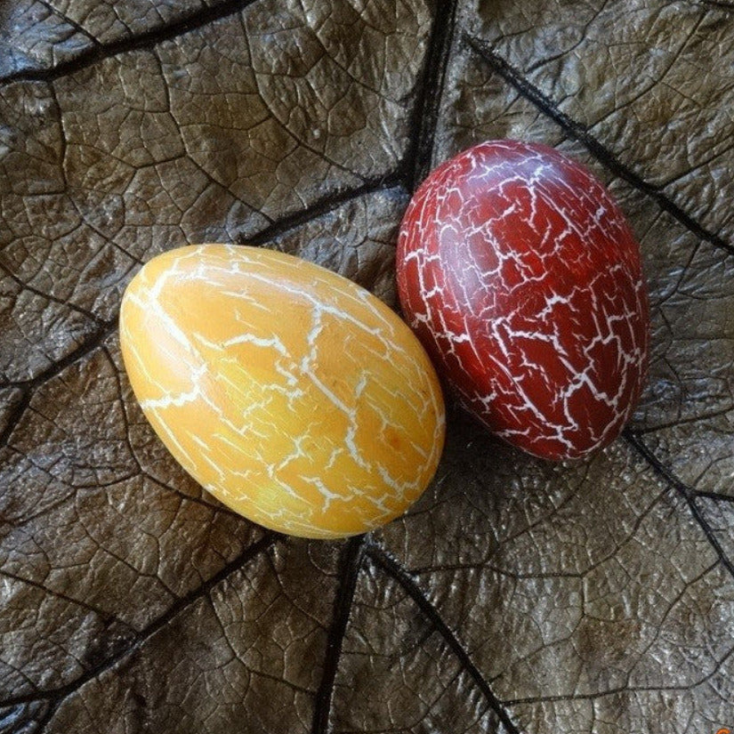 Magis Art Shop decorative duck eggs with a yellow and red crackled paint finish resting on a large brown leaf