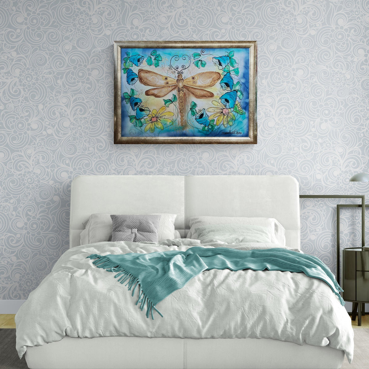 Magis Art Shop silk painting of a dragonfly with gold details and floral wreath in a framed wall display above a bed