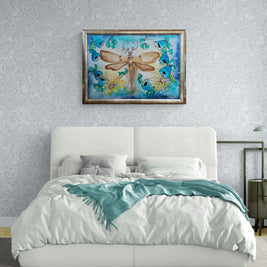 Magis Art Shop silk painting of a dragonfly with gold details and floral wreath in a framed wall display above a bed