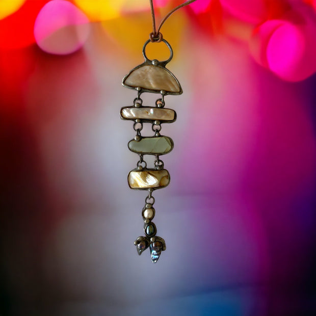 Magis Art Shop artisan fish-shaped pendant made with fluorite, mother-of-pearl, and river pearls using tin soldering.