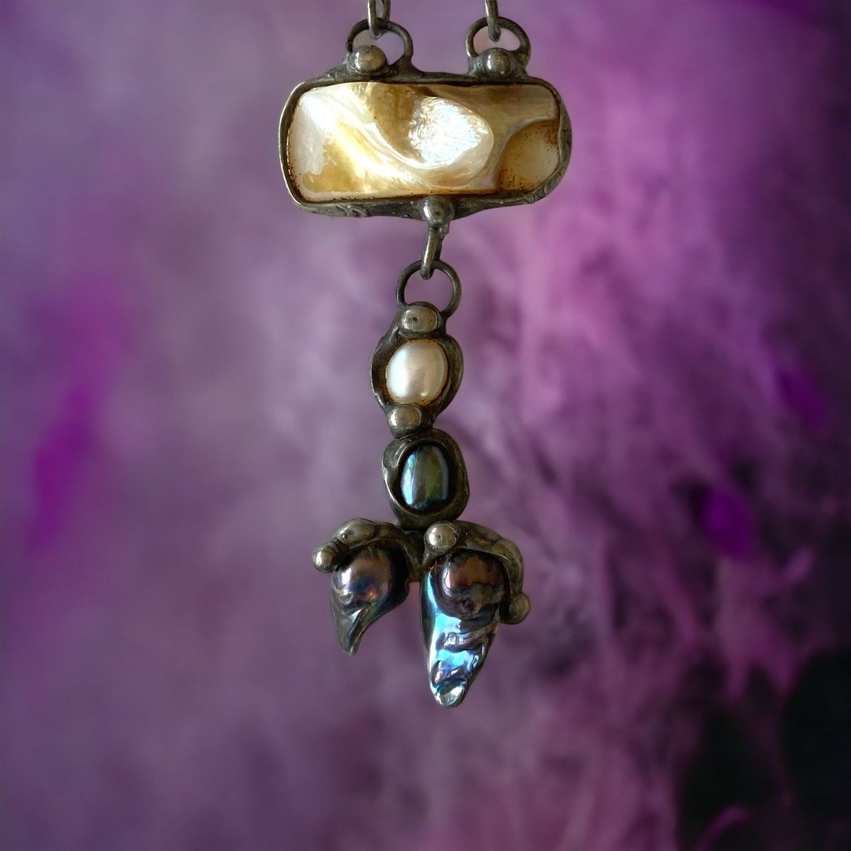 Magis Art Shop artisan necklace featuring fluorite, mother of pearl, and river pearls in a handcrafted tin setting.