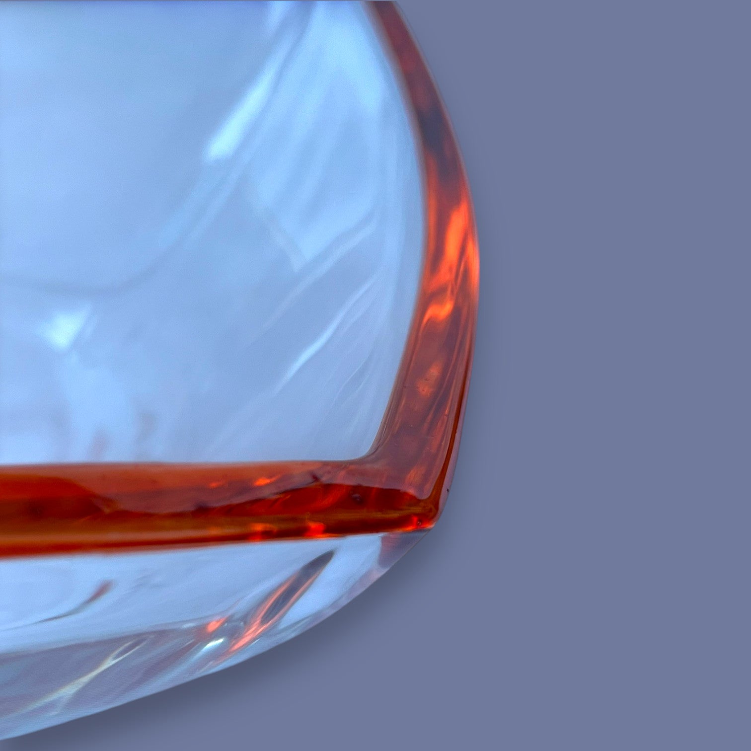 Magis Art Shop large glass bowl with a vibrant orange rim, showcasing elegant curved design and clear glass texture.