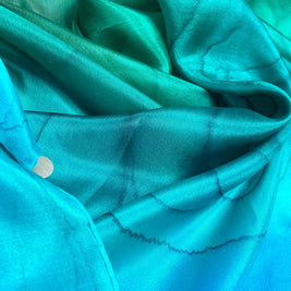 Magis Art Shop Elena Ruta Marchallé silk scarf in vibrant green and blue gradient with delicate line patterns.