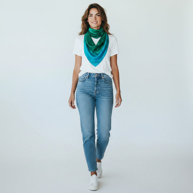 Magis Art Shop green and blue silk scarf worn by a woman in a white t-shirt and jeans against a white background.
