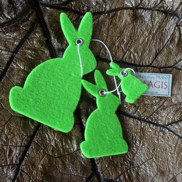 Magis Art Shop green felt bunny hanging decorations in three different sizes on a dark leaf background
