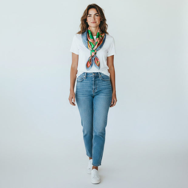 Magis Art Shop silk scarf in green and orange worn by a woman in a white t-shirt and blue jeans