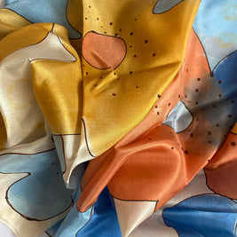 Magis Art Shop hand-painted silk scarf featuring abstract blue and orange floral patterns with delicate outlines.