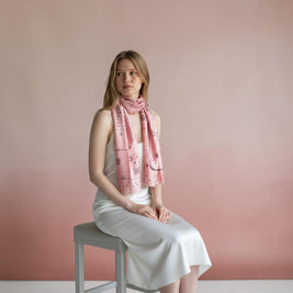Magis Art Shop Ria Berec pink silk scarf with polka dot pattern worn by a woman in a white dress
