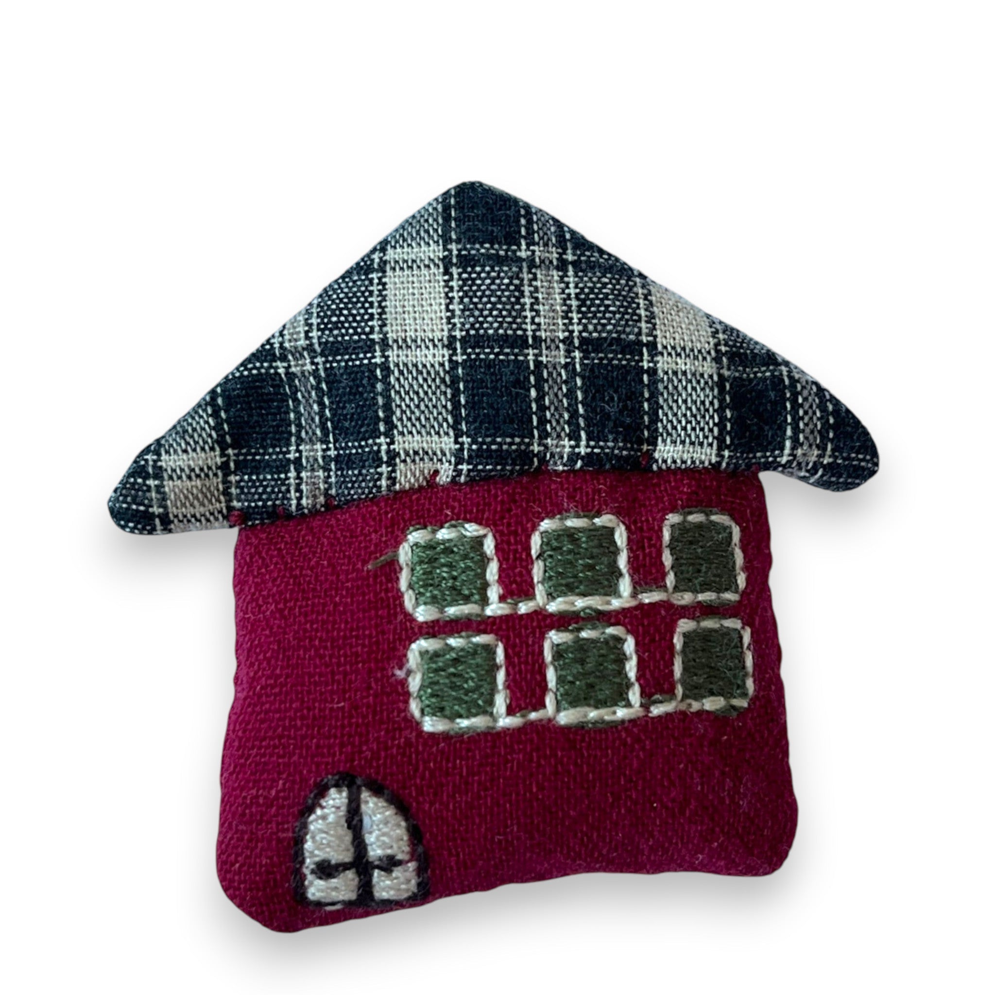 Magis Art Shop handmade red fabric house brooch with a black and white plaid roof and embroidered window details.