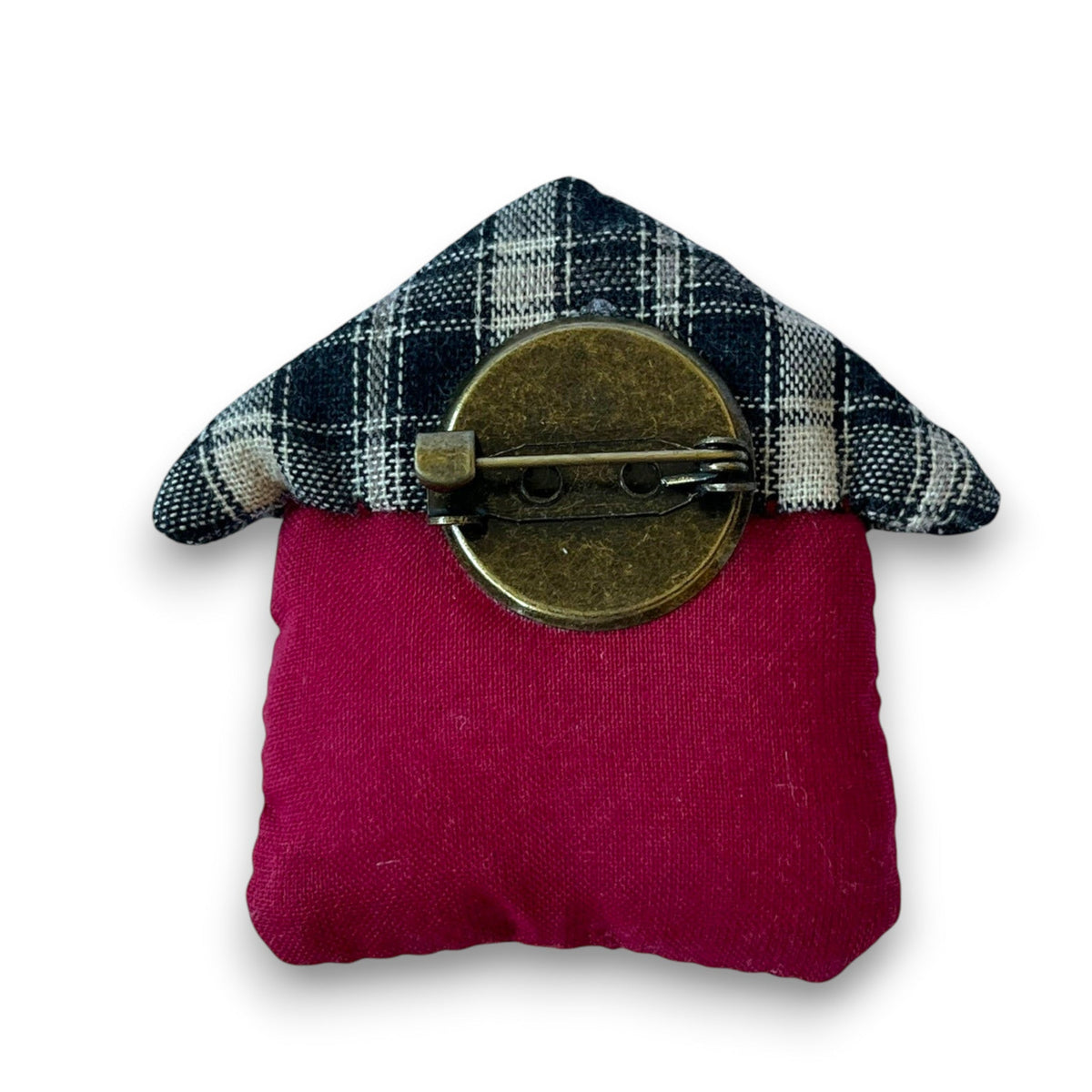 Magis Art Shop textile house brooch with a red base, plaid roof, and bronze pin backing on a white background.