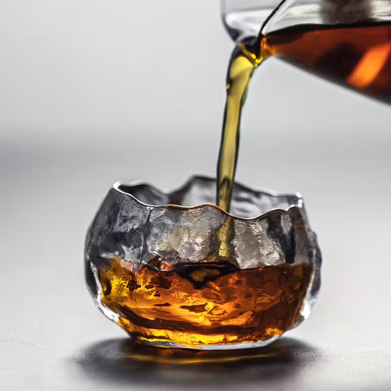Magis Art Shop small clear glass cup with an organic, textured rim being filled with dark coffee or tea