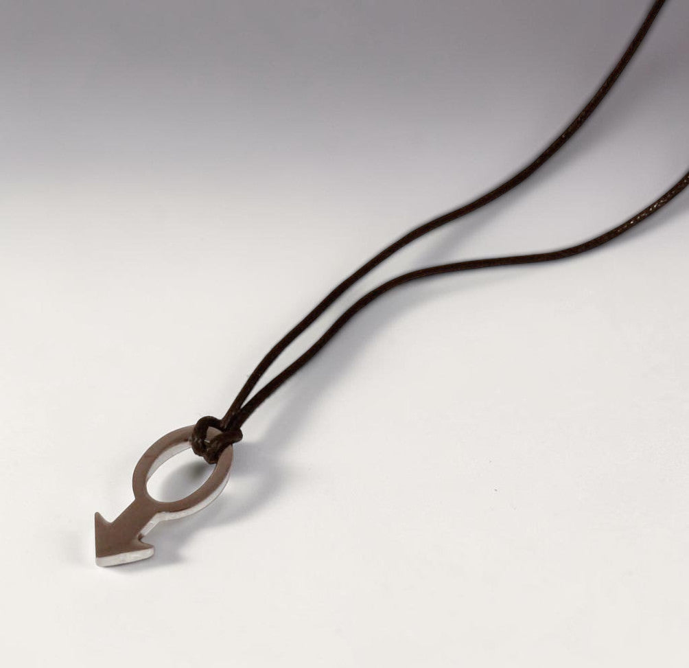 Magis Art Shop stainless steel pendant necklace featuring a minimalist arrow design on a dark brown cord