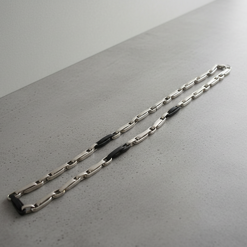 Magis Art Shop stainless steel chain necklace with modern black accent links on a grey surface