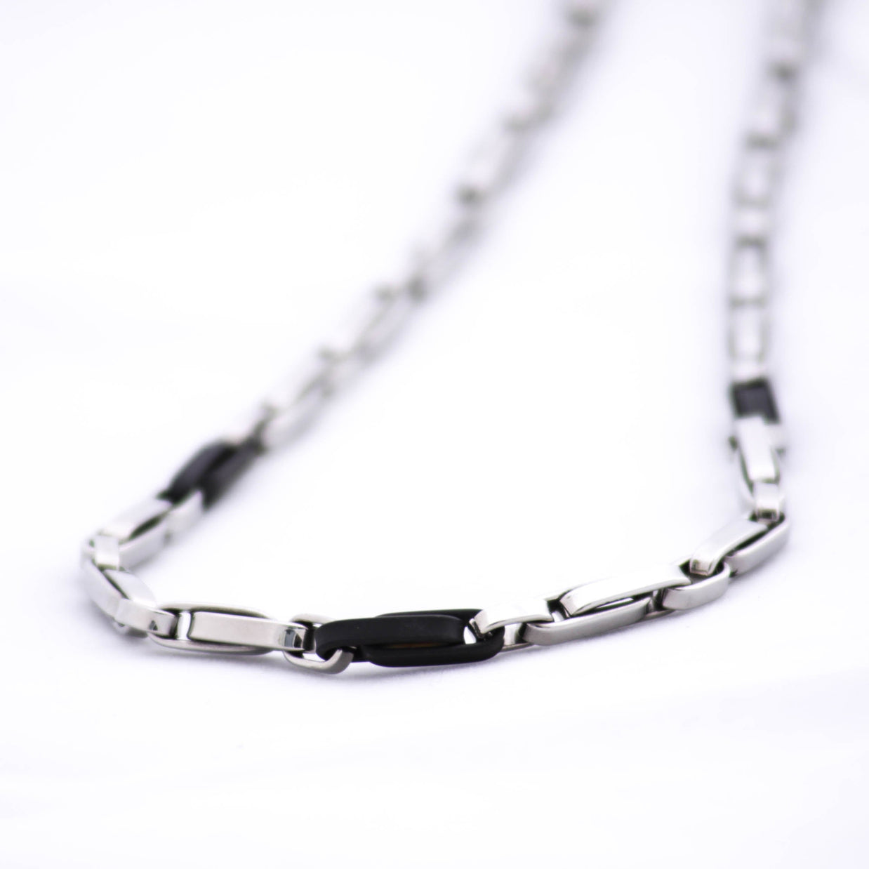 Magis Art Shop stainless steel necklace featuring a modern bicolor design with alternating silver and black links.