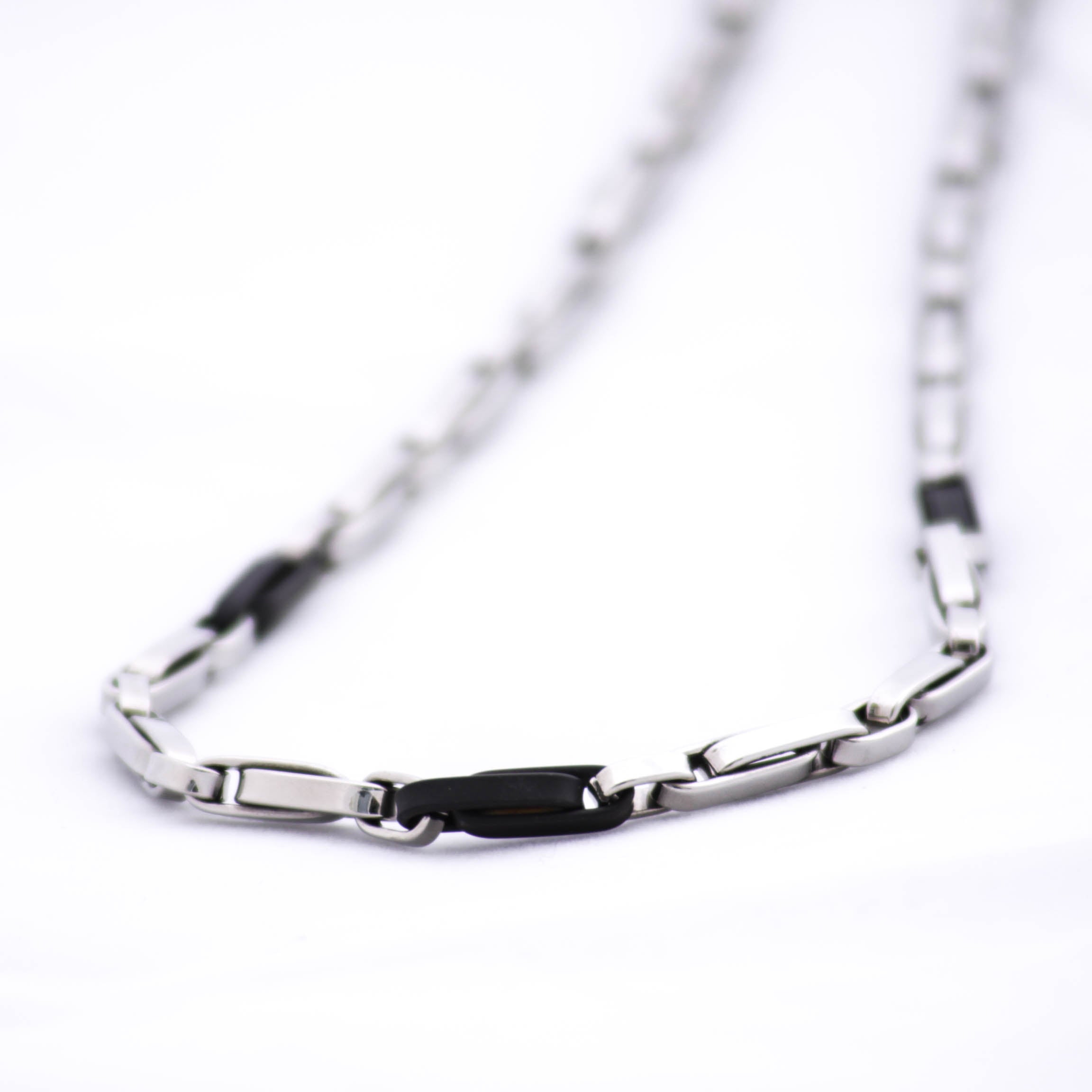 Magis Art Shop stainless steel necklace featuring a modern bicolor design with alternating silver and black links.