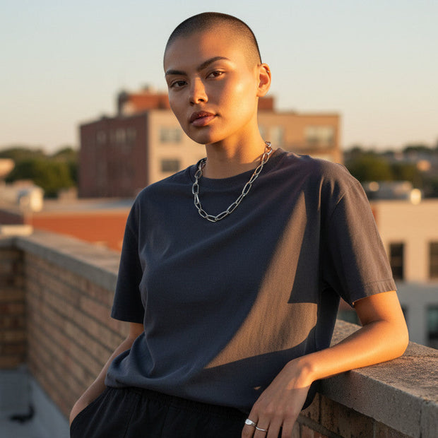 Magis Art Shop stainless steel chain necklace with large links worn by a model on a rooftop at sunset
