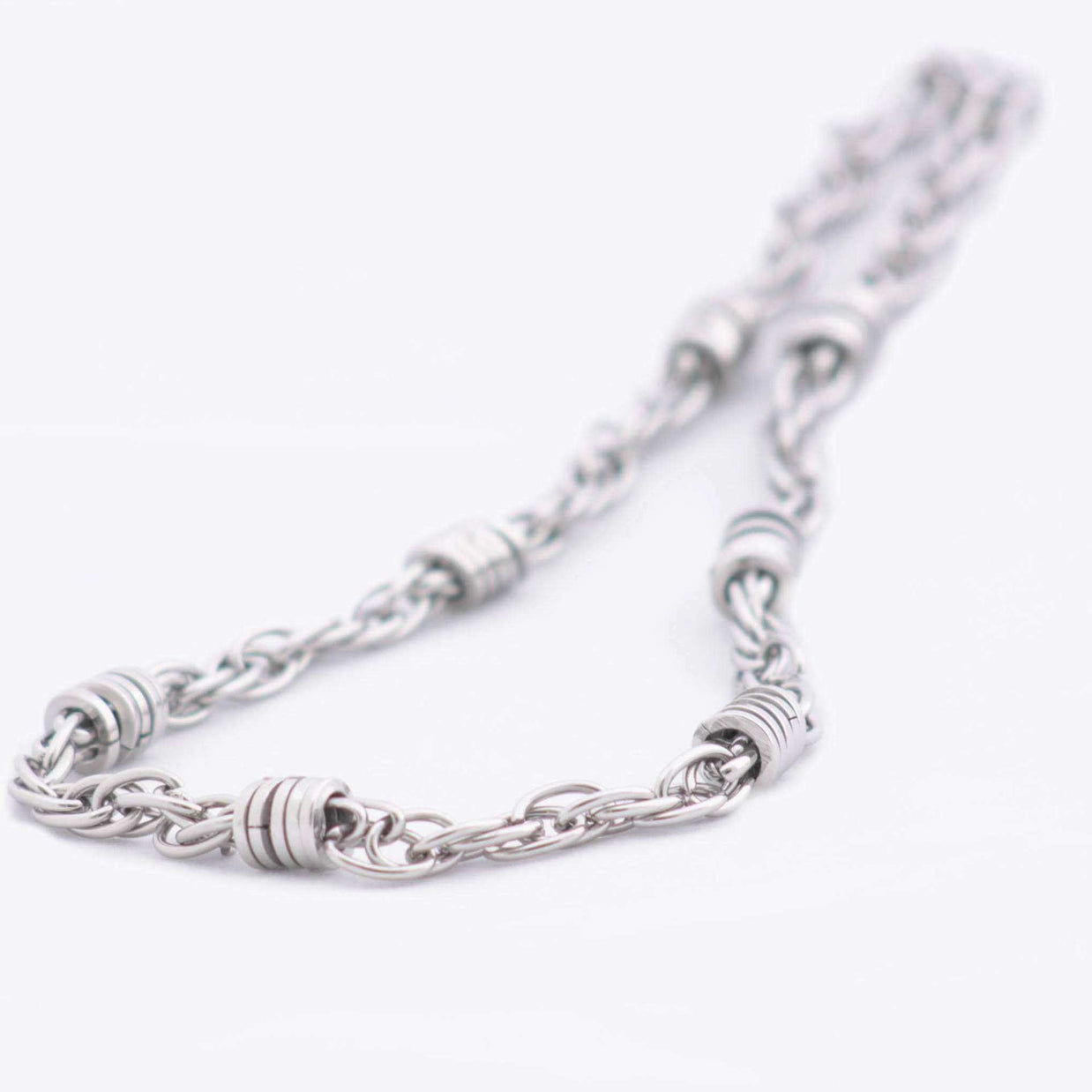 Magis Art Shop stainless steel chain necklace featuring decorative metal rings on a silver-toned link chain