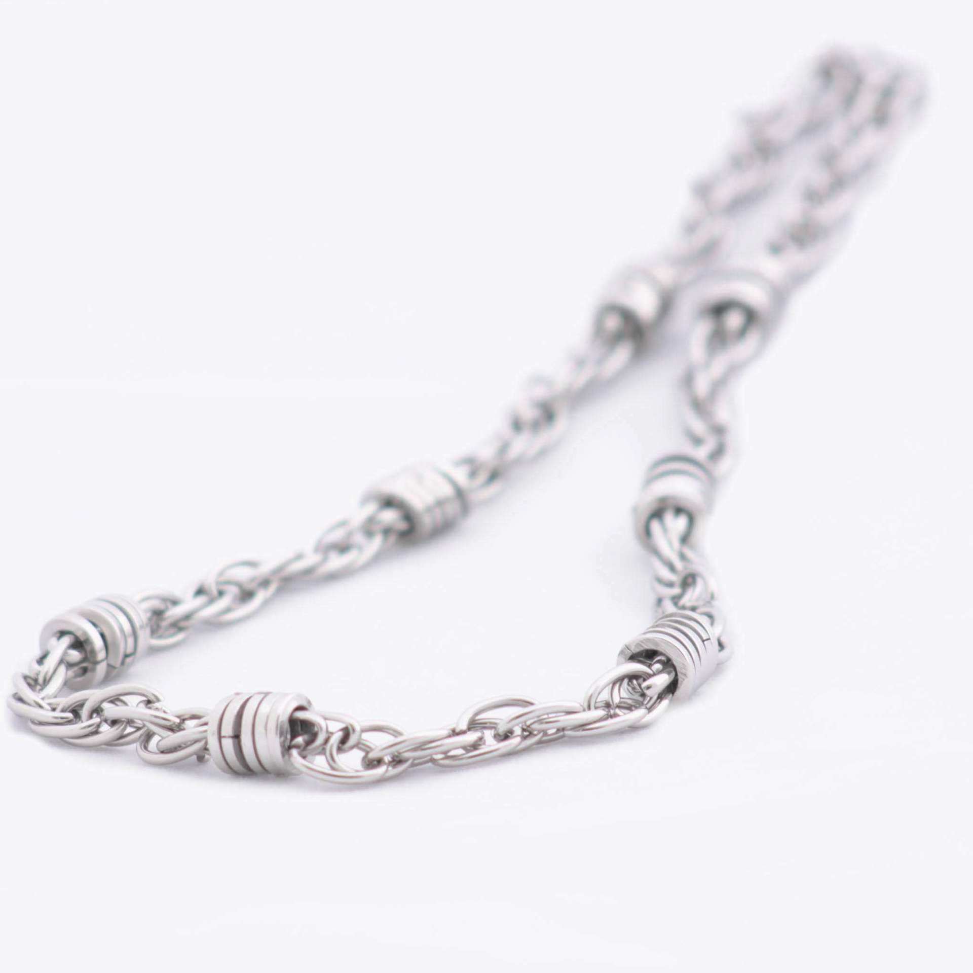 Magis Art Shop stainless steel chain necklace featuring decorative metal rings on a silver-toned link chain