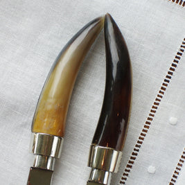 Magis Art Shop butter knife with a curved handle made of natural tortoise bone, showing light and dark variations.