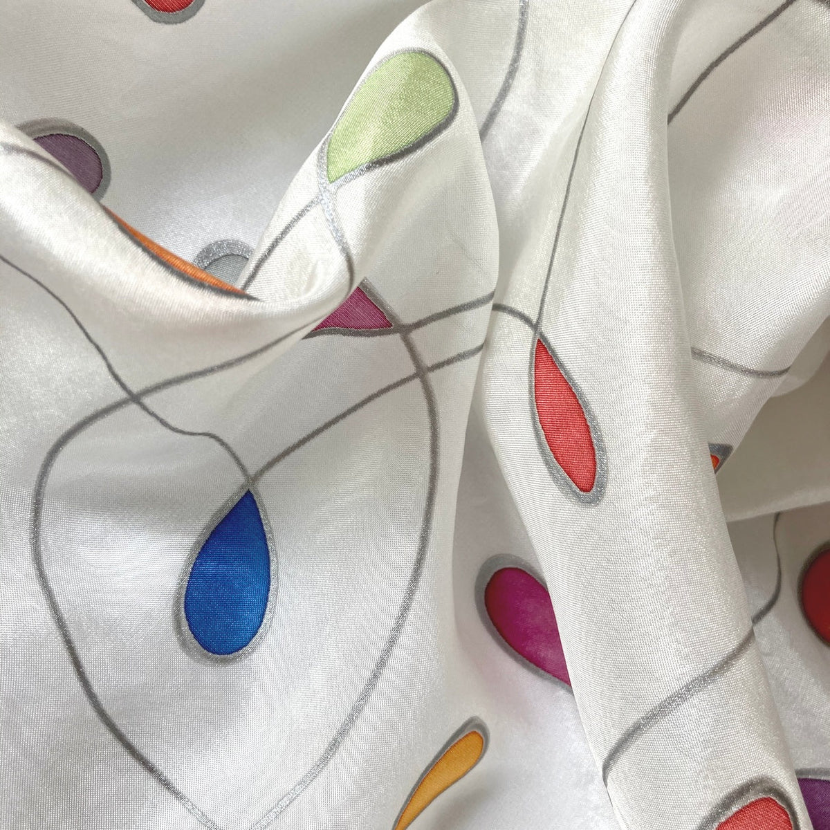 Magis Art Shop white silk scarf by Jana Melichová featuring colorful teardrop patterns and silver outlines.